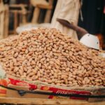 Large pile of cocoa beans on a vendor stand in a market, ready for trade.